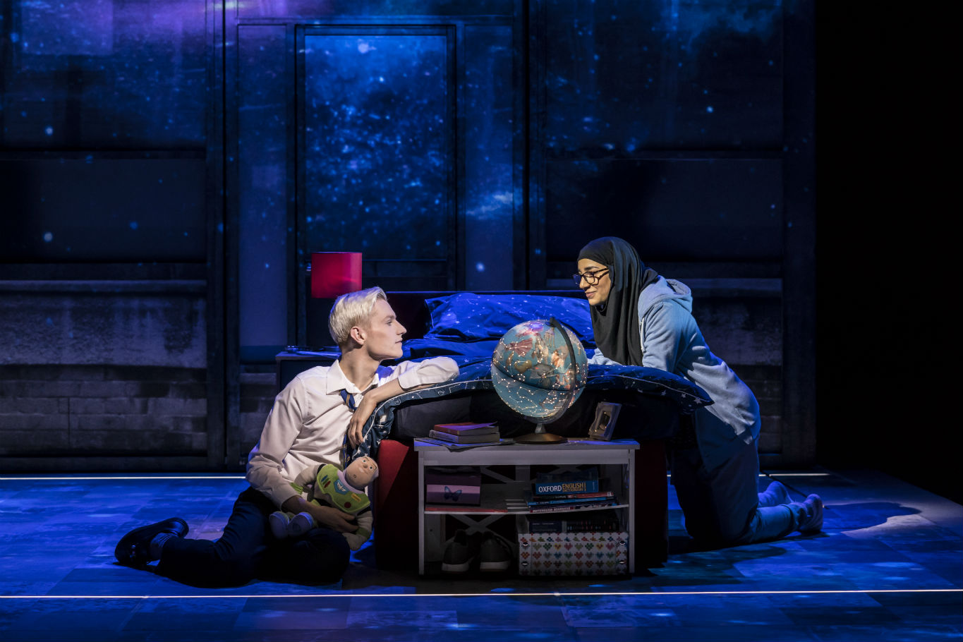 Two performers talk on the starlit stage of Everybody's Talking About Jamie